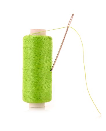green Bobbin with needle isolated on whiteの写真素材