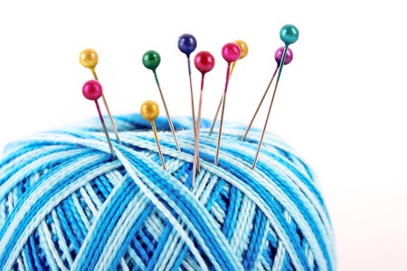 Few pins in wool ball isolated on whiteの写真素材