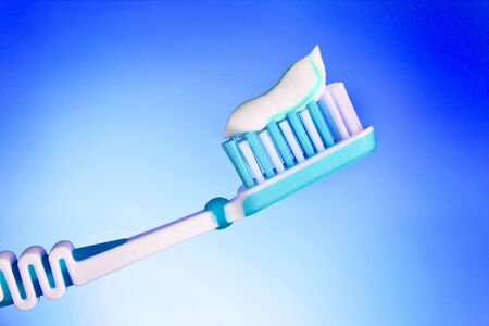 toothbrush with toothpaste on a blue background