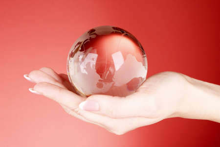 Crystal ball on hand. Red backgroundの写真素材