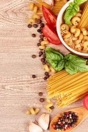 spaghetti with garlic, onion, spices  and basil on a yellow backgroundの写真素材