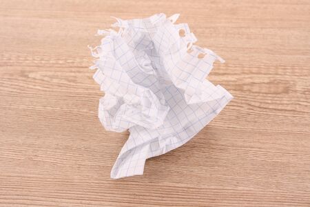 crumpled paper ball on wooden textureの写真素材