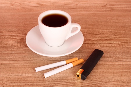 Cigarettes and cup of coffee on wooden backgroundの写真素材