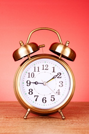 Old alarm-clock on red backgroundの写真素材