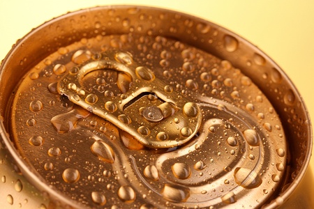 Golden metallic beer with water drops on yellow backgroundの写真素材