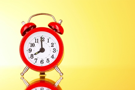 Alarm-clock on yellow background