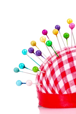 Colored pinheads in pin-cushion isolated on whiteの写真素材