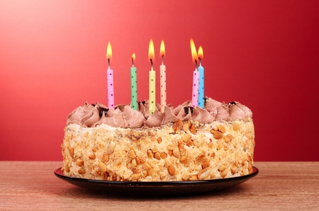 Cake with candles on red backgroundの写真素材
