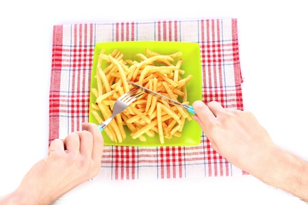 French fries on a plate and cutlery isolated on white
