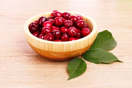 cherry in bowl on wooden backgroundの写真素材