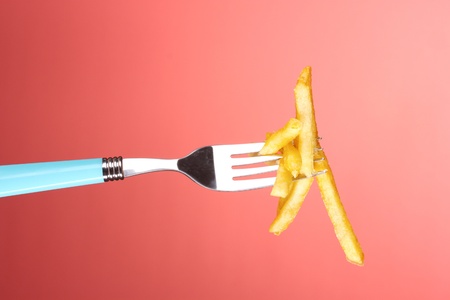French fries and fork on red backgroundの写真素材