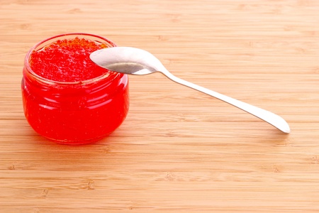 Red caviar on spoon on wooden tableの写真素材