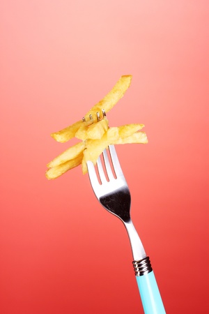French fries and fork on red backgroundの写真素材