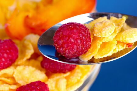 tasty cornflakes and fruit  in glass bowl on blue backgroundの写真素材