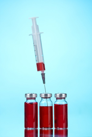 medical ampoules and syringe on blue backgroundの写真素材