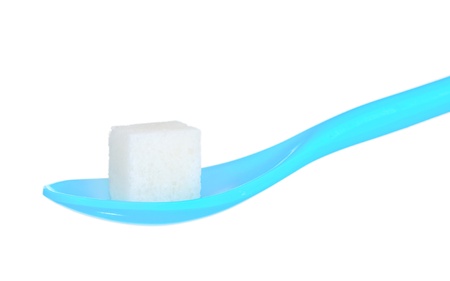lump sugar in blue plastic spoon isolated on whiteの写真素材