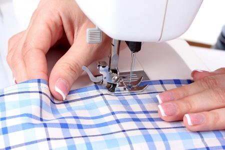 sewing machine, blue fabric and women's handsの写真素材