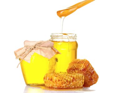 Beautiful combs, spoon and honey in jar isolated on whiteの写真素材