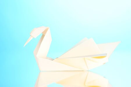 Origami paper swan on blue backgroundの写真素材