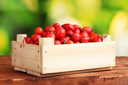ripe briar in wooden box on wooden table on green backgroundの写真素材