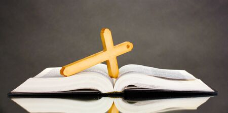 Russian bible and wooden cross on black background