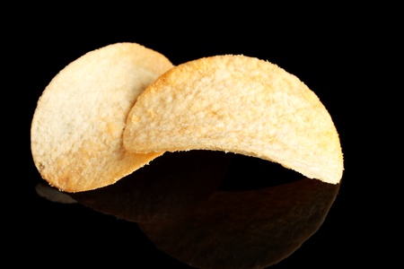 Delicious potato chips on black background