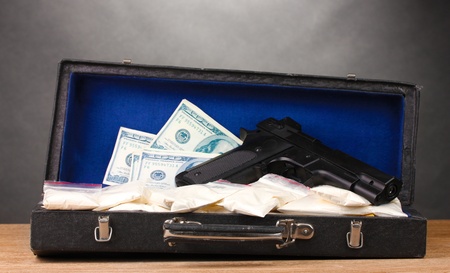 Cocaine, dollars and handgun in case on wooden table on grey backgroundの写真素材