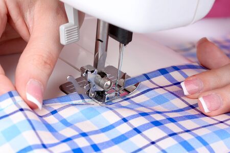 sewing machine, blue fabric and women's handsの写真素材