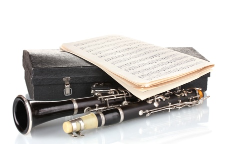 Antique clarinet, case and notebook with notes isolated on whiteの写真素材