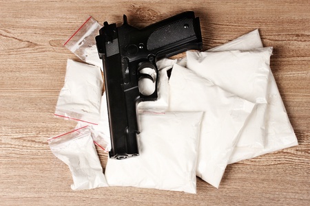 Cocaine in packages and handgun on wooden backgroundの写真素材