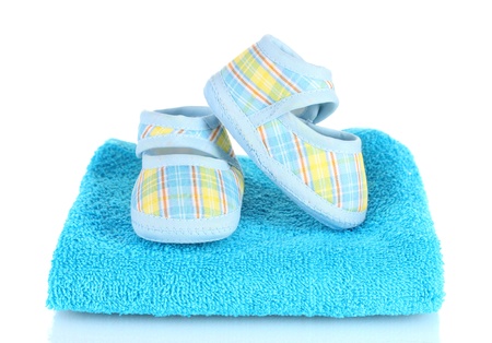 Blue baby booties on blue towel isolated on whiteの写真素材