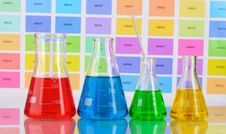 Laboratory flasks with color liquid on color samples backgroundの写真素材