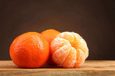 tangerines on wooden table on brown backgroundの写真素材