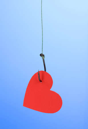 Heart on fish hook on blue backgroundの写真素材