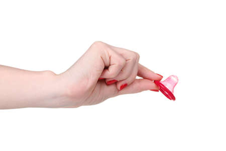 Hand holding a condom isolated on whiteの写真素材