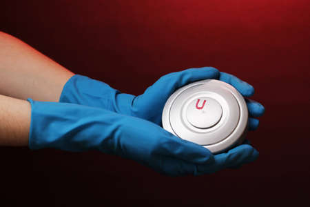 Uranium in hand on red background