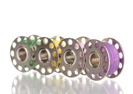 Metal spools of thread isolated on white