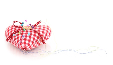 Colored pinheads in pin-cushion isolated on whiteの写真素材