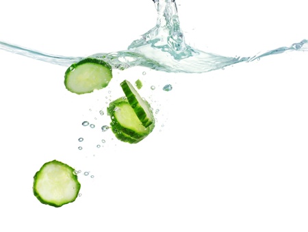 fresh sliced cucumber in water isolated on whiteの写真素材
