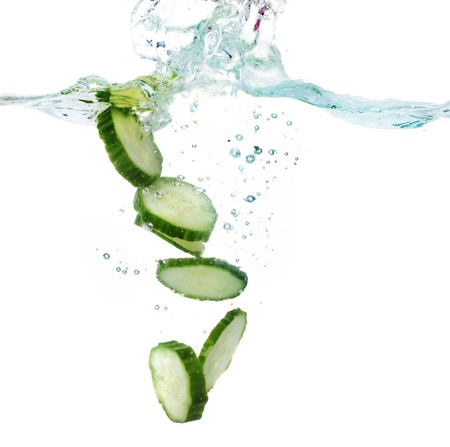 fresh sliced cucumber in water isolated on whiteの写真素材