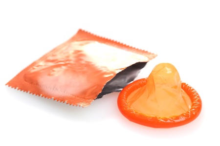 Orange condom with  open pack isolated on whiteの写真素材