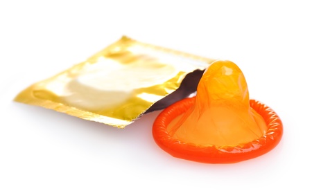 Orange condom with  open pack isolated on whiteの写真素材