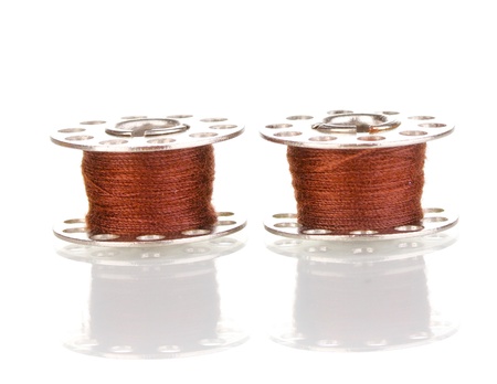 Metal spools of thread isolated on whiteの写真素材