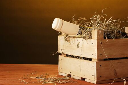Bottle of great wine in crate on wooden table on brown backgroundの写真素材