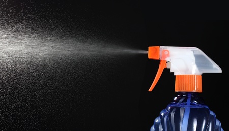 spray bottle and spraying on black background