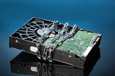Hard disk drive on chain on dark blue background