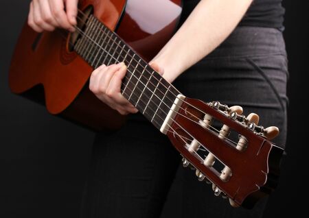 Guitar in hands isolated on blackの写真素材