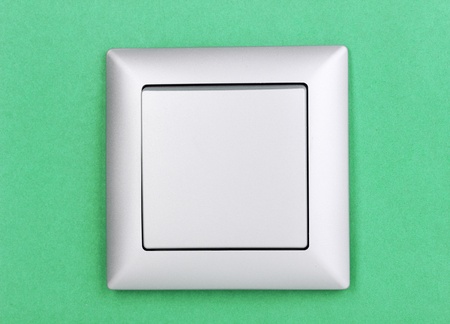 Modern light switch on green backgroundの写真素材
