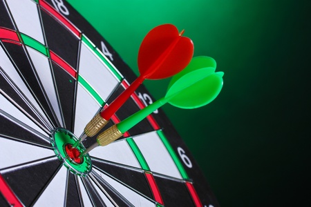 dart board with darts on green backgroundの写真素材