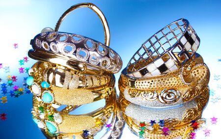 Beautiful gold bracelets on blue background